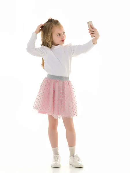 Het meisje gebruikt een mobiele telefoon.Het concept van mensen en technologie. — Stockfoto