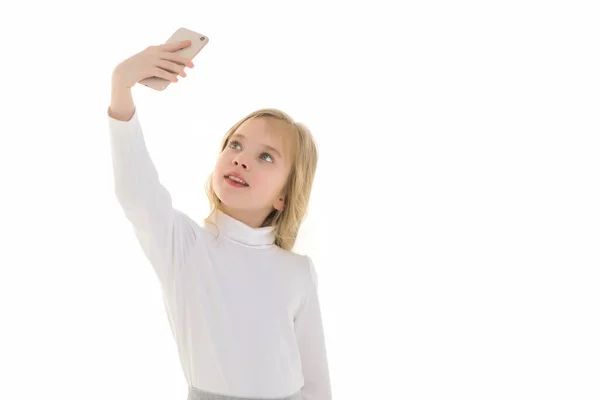 La niña está usando un teléfono celular. El concepto de personas y tecnología. — Foto de Stock
