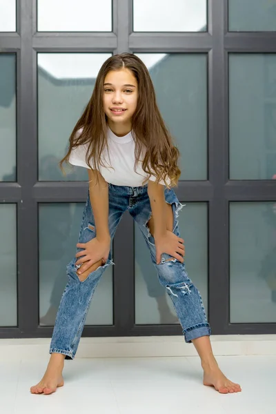 Bambina in posa in studio vicino a una grande finestra panoramica — Foto Stock