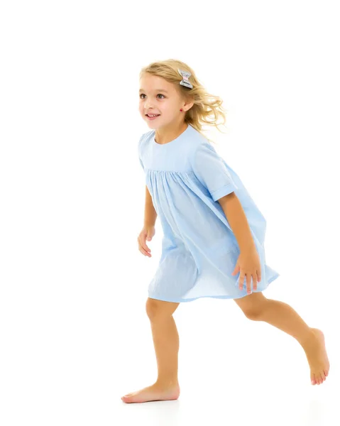 Милая маленькая девочка весело бегает по комнате. Концепция детских игр — стоковое фото