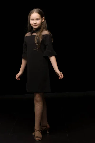 Nettes kleines Mädchen in einem schönen Kleid auf schwarzem Hintergrund. — Stockfoto