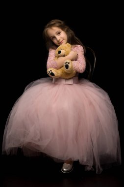 Güzel Pembe Elbiseli Kız Oyuncak Ayıya Şefkatle Sarılıyor.