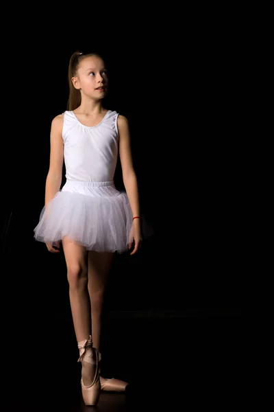 검은 배경으로 스튜디오에서 춤추고 있는 소녀가 투 투 투앤 포인트 신발을 신고 있습니다. — 스톡 사진