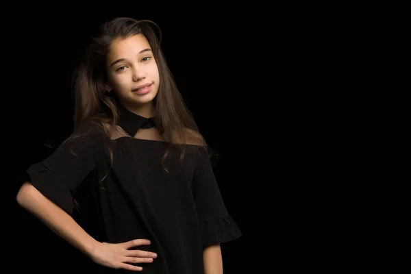 Primer plano.Retrato de una linda niña sobre un fondo negro. —  Fotos de Stock