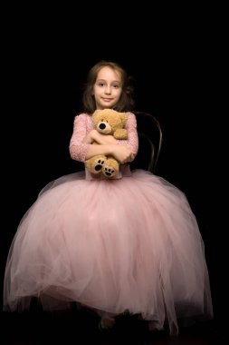 Güzel Pembe Elbiseli Kız Oyuncak Ayıya Şefkatle Sarılıyor.