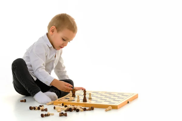 Menino pensativo sentado no chão jogando xadrez — Fotografia de Stock