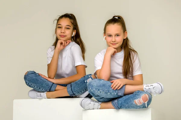 二人の小さな女の子posingでザスタジオ上のホワイトキューブ — ストック写真
