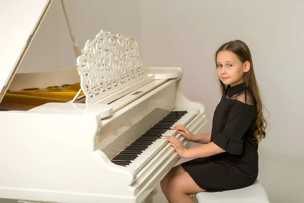 Kız beyaz piyanonun başında.. — Stok fotoğraf