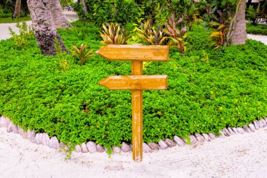 Ok şeklinde ahşap tabela ve elle boyanmış bir mesaj.