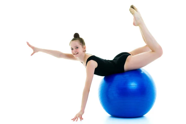 小女孩在一个大球上做运动以锻炼身体. — 图库照片