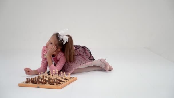 Девочка играет в шахматы. На белом фоне.. — стоковое видео