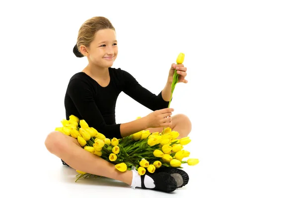 Hermosa gimnasta niña con un ramo de flores en el estudio. El concepto de victoria deportiva. —  Fotos de Stock