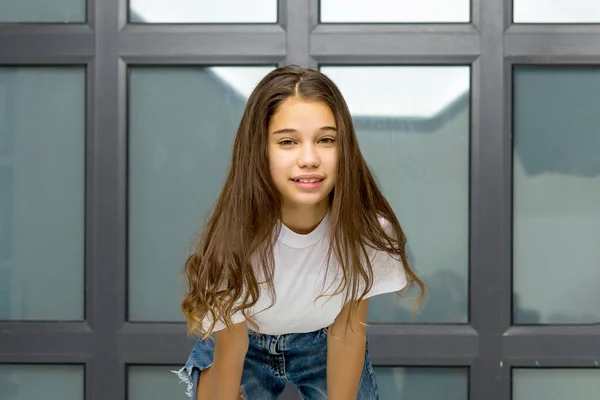 Μικρό κορίτσι που ποζάρει στο στούντιο κοντά σε ένα μεγάλο πανοραμικό παράθυρο — Φωτογραφία Αρχείου