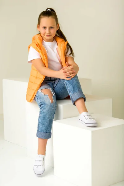 Bambina posa per una rivista in studio su un cubo bianco. — Foto Stock