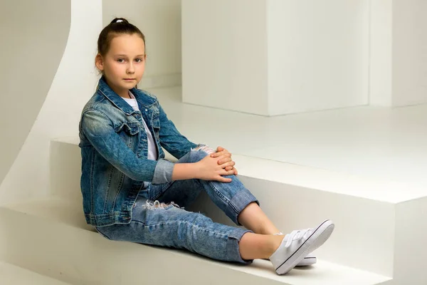 Κοριτσάκι που κάθεται σε ένα λευκό κύβο με σταυρωτά πόδια. — Φωτογραφία Αρχείου