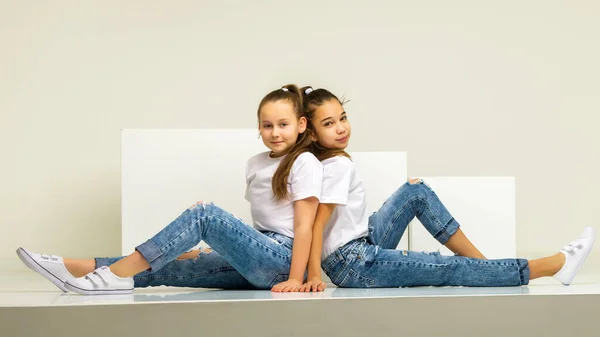 Dos niñas posando en el estudio sobre cubos blancos —  Fotos de Stock