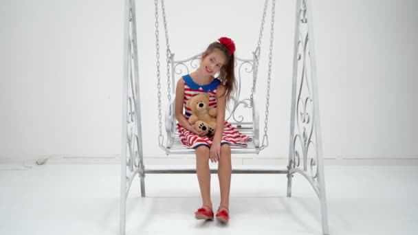 小さな女の子がテディベアでスイングしています. — ストック動画