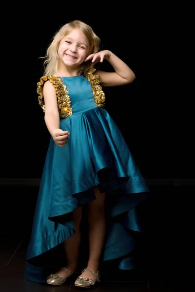 Menina feliz bonita em vestido azul agradável e sorrindo para a câmera — Fotografia de Stock