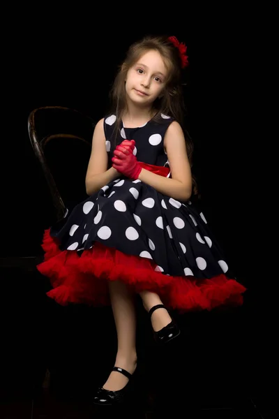 Meisje in Retro stijl Polka Dot jurk zitten met haar handen sluiting — Stockfoto