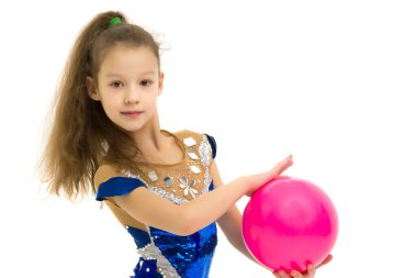 Kız jimnastikçi, topla egzersiz yapıyor..