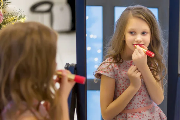 Charmant langharig meisje toepassen van lippenstift in de voorkant van spiegel. — Stockfoto