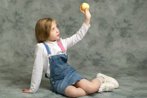 Malá holčička s jablkem.Studio portrét. — Stock fotografie