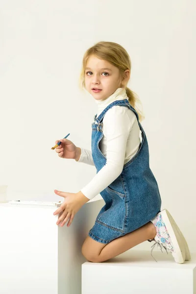 Cute Blonde Girl Sitting on Her Knees and Painting with Brush. — Stock Photo, Image