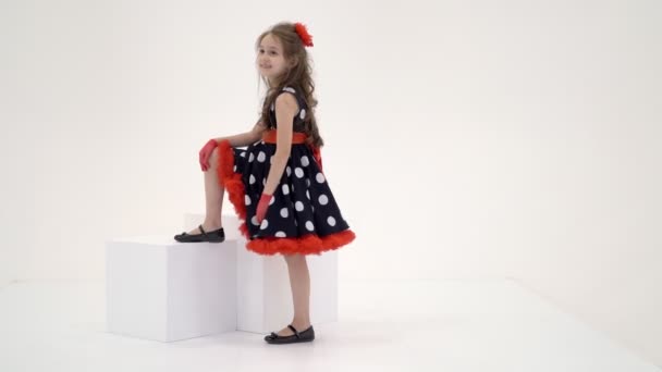 Porträtt av avslappnad flicka sitter på kuben tittar allvarligt på kameran — Stockvideo
