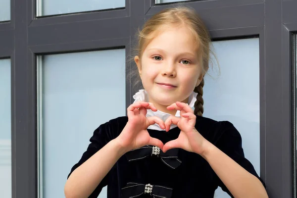 Kleines Mädchen zeigt Herz mit den Händen. — Stockfoto