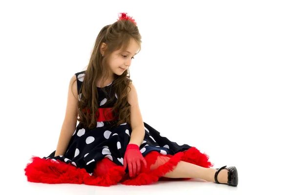 Όμορφο κορίτσι που φοράει πουά φόρεμα κάθεται στο πάτωμα — Φωτογραφία Αρχείου
