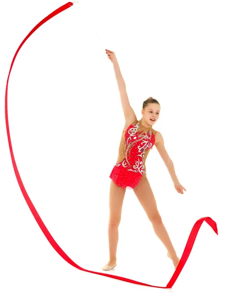Dziewczyna gimnastyczka wykonuje ćwiczenia z taśmą. — Zdjęcie stockowe
