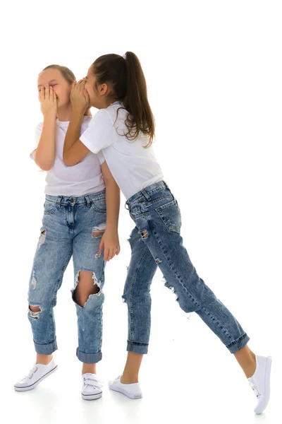 Twee vrolijke kleine meisjes delen geheimen in elkaars oor. — Stockfoto