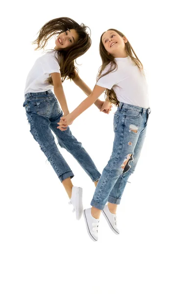 Two happy children jumping at once on a white background — Stock Photo, Image