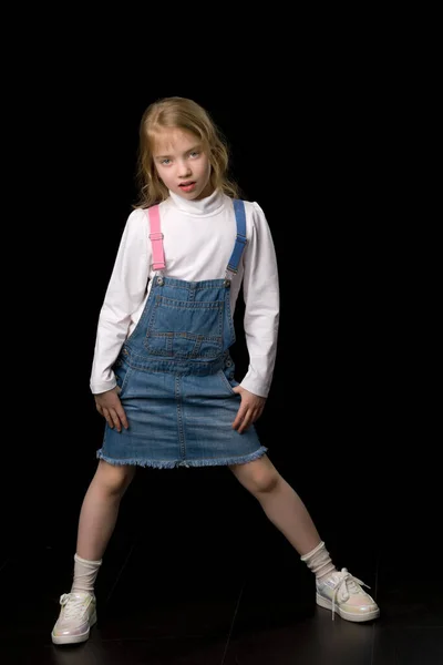 Liten flicka i en kort denim klänning. — Stockfoto
