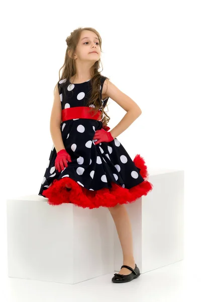 Menina em Polka Dot Dress, luvas vermelhas e arco em pé olhando Awa. — Fotografia de Stock