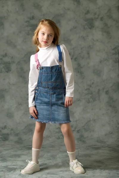 Kleines Mädchen im kurzen Jeanskleid. — Stockfoto