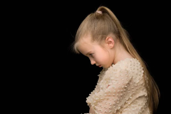 Das kleine Mädchen denkt isoliert. Auf schwarzem Hintergrund. — Stockfoto