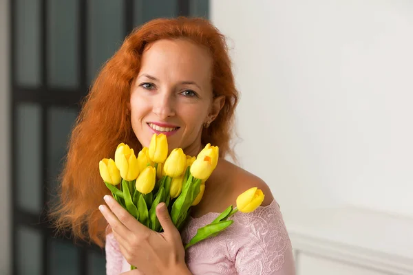 Joyeux jeune femme avec un bouquet de fleurs. Portrait studio. — Photo