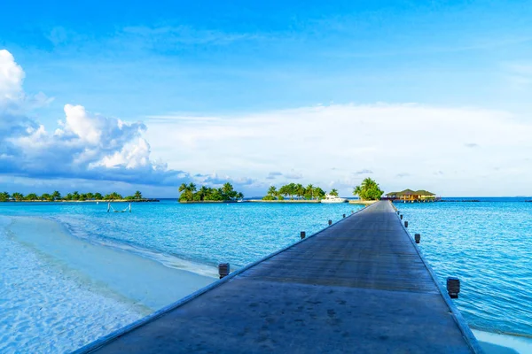 Widok na drewniany pomost na egzotycznym wybrzeżu z jasną błękitną wodą i niebem — Zdjęcie stockowe