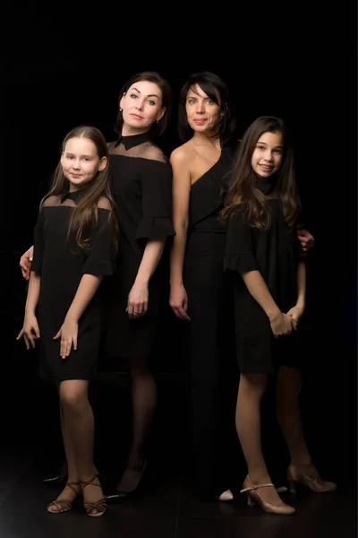 İki güzel kızı olan genç ve güzel anneler. Siyah bir arkaplanda stüdyo resmi. — Stok fotoğraf
