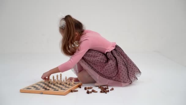 Девочка играет в шахматы. На белом фоне.. — стоковое видео