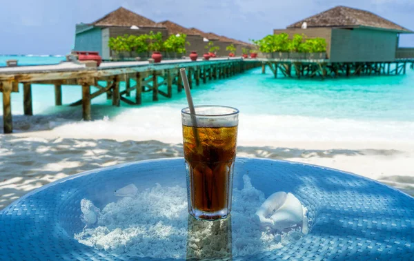 A glass of cold cocktail on a table on the beach in a restaurant. Maldives