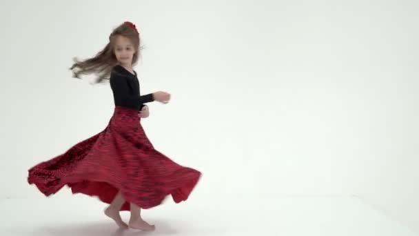Schöne kleine Mädchen in einem Kleid dreht sich im Tanz. Das Konzept einer glücklichen Kindheit, Tanz, Urlaub. Auf weißem Hintergrund. — Stockvideo