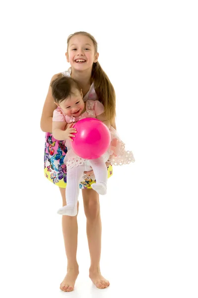 Niedliche glückliche Mädchen lachen und spielen zusammen mit rosa Luftballon — Stockfoto