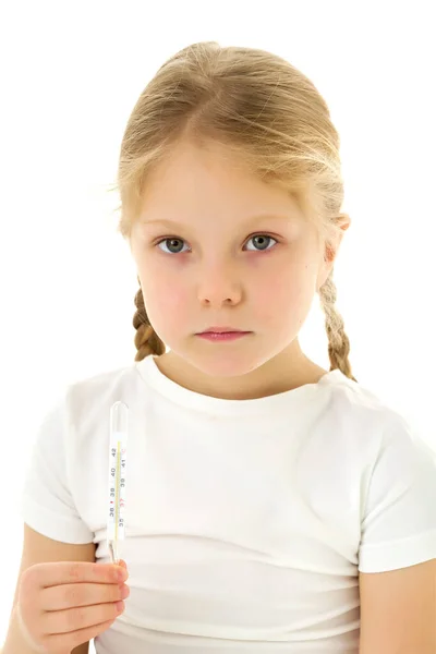 Een klein meisje in een schoon wit T-shirt houdt een thermometer in haar hand. Covid-19 concept, virus, ziekte, behandeling. — Stockfoto