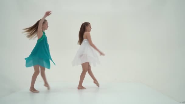 Twin Sisters visel sport ruhák tánc ellen fehér háttér.