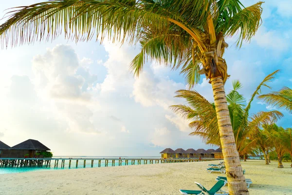 Houten bruggen die leiden naar de hutten aan de kust van de tropische, warme zee. Malediven. Toerisme. — Stockfoto