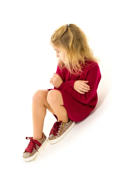 Αναστατωμένη κοπέλα που κάθεται στο πάτωμα με τα γόνατα ψηλά και τα χέρια διπλωμένα. — Φωτογραφία Αρχείου