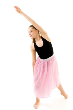 Genç kız jimnastikçi Tiptoe 'da duruyor ve yan tarafa bakıyor.