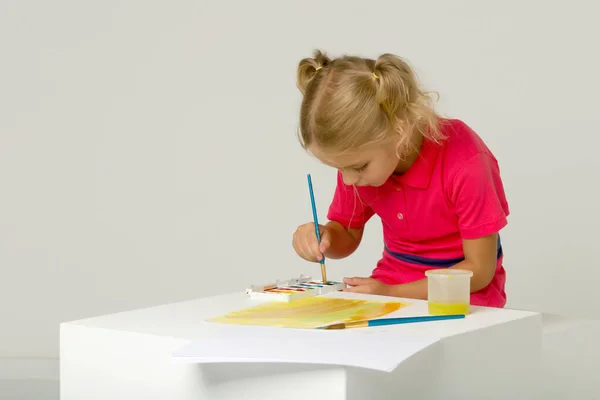 Belle fille blonde debout à la table et peinture à l'aquarelle — Photo